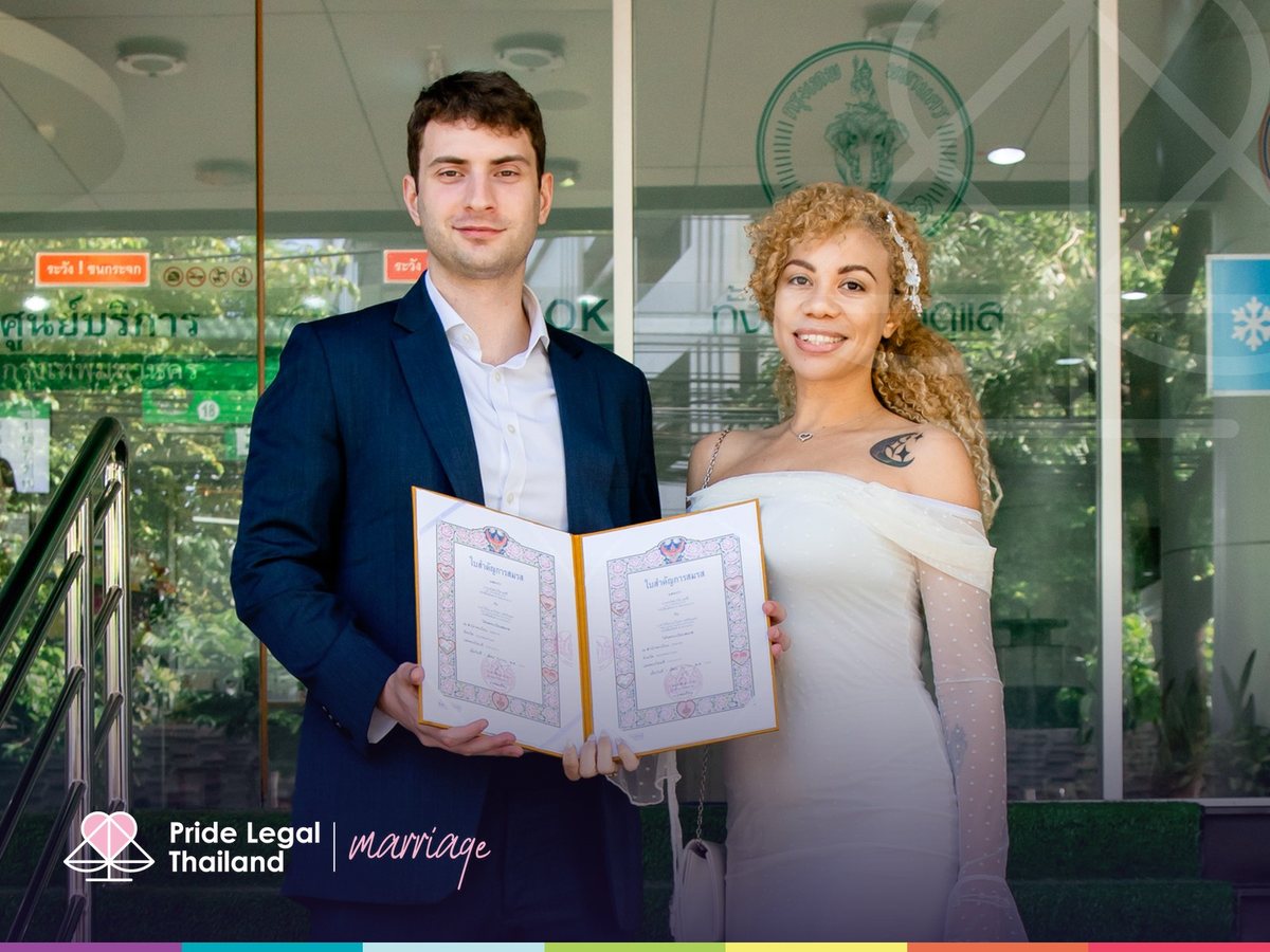 A couple holding their Thai marriage certificates at the district office
