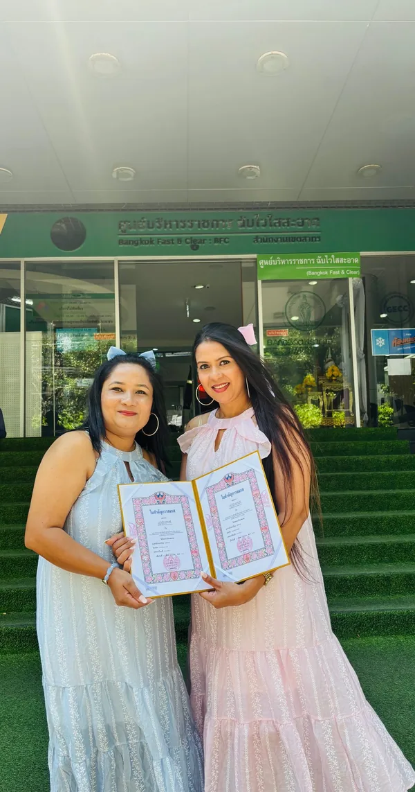 A married couple holding their marriage certificates outside the district office in Bangkok